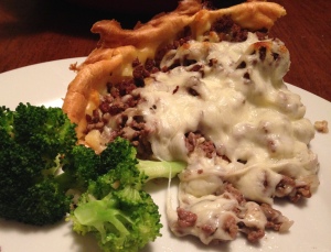Big slice of beef and cheese gougere with broccoli
